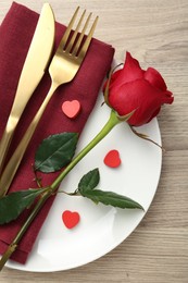 Photo of Romantic place setting with red rose on wooden table, top view. Valentine's day celebration