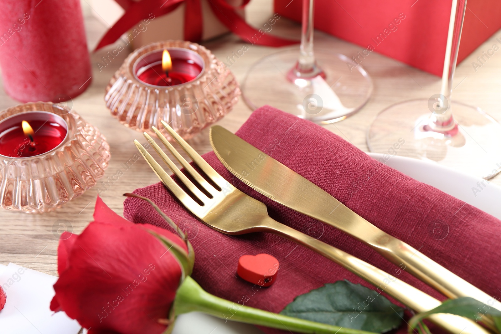 Photo of Romantic place setting with red rose on white table, closeup. Valentine's day celebration