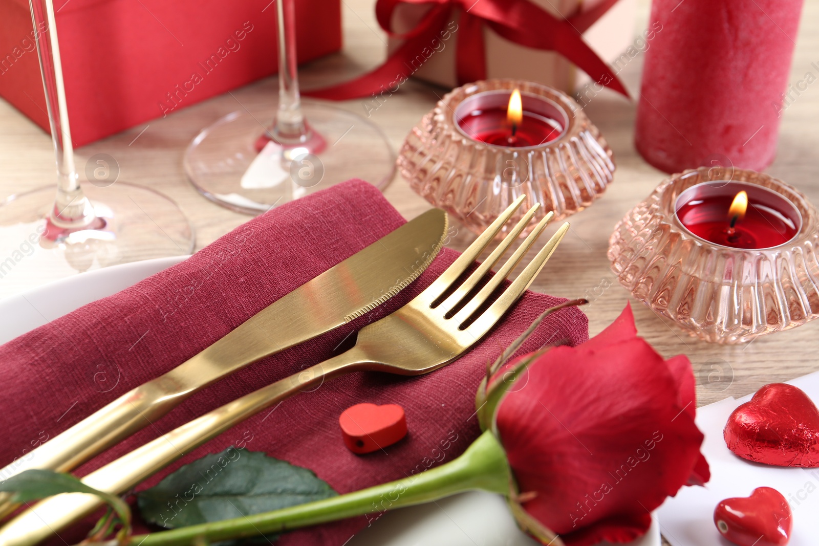 Photo of Romantic place setting with red rose on white table, closeup. Valentine's day celebration