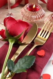 Romantic place setting with red rose on white table, closeup. Valentine's day celebration