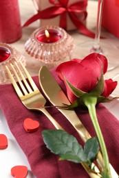 Photo of Romantic place setting with red rose on white table, closeup. Valentine's day celebration