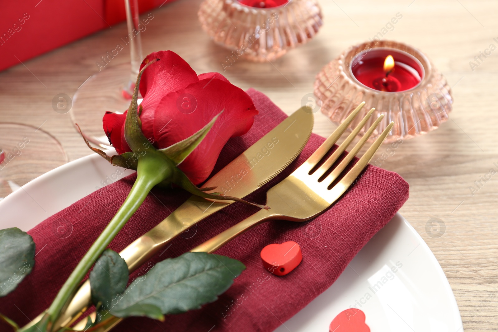 Photo of Romantic place setting with red rose on white table, closeup. Valentine's day celebration