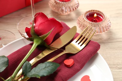 Photo of Romantic place setting with red rose on white table, closeup. Valentine's day celebration