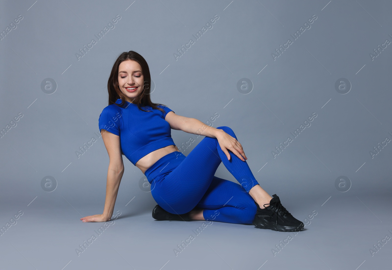 Photo of Beautiful woman in stylish sportswear on grey background