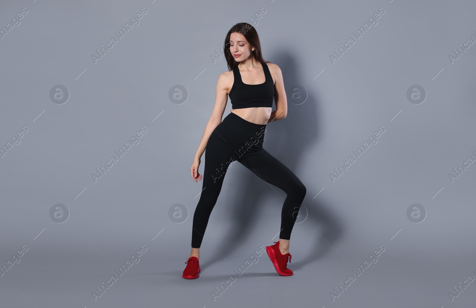 Photo of Beautiful woman in stylish sportswear on grey background