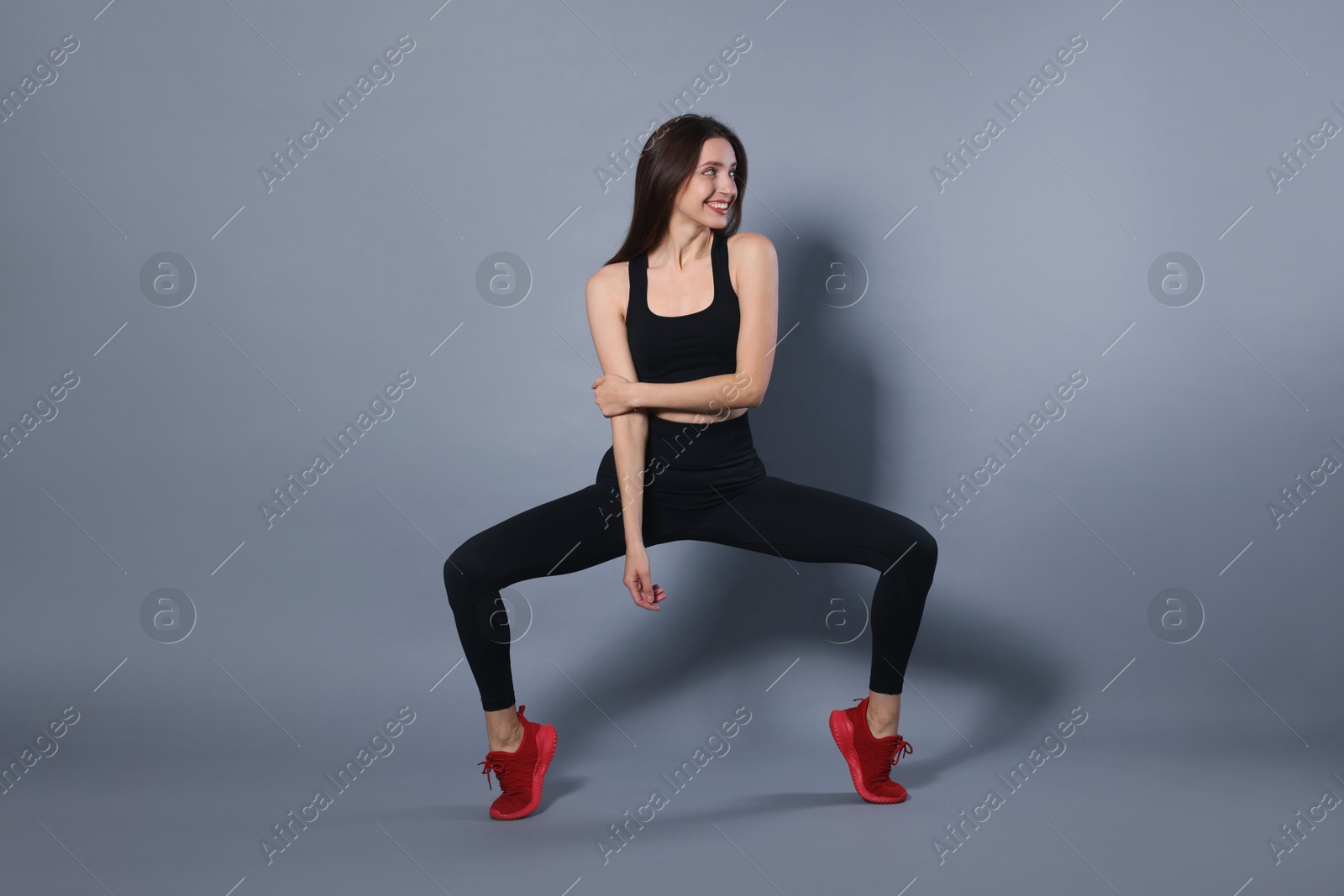 Photo of Beautiful woman in stylish sportswear on grey background