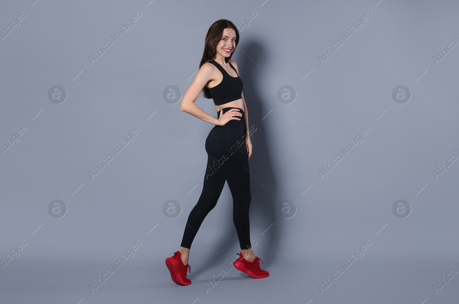 Photo of Beautiful woman in stylish sportswear on grey background