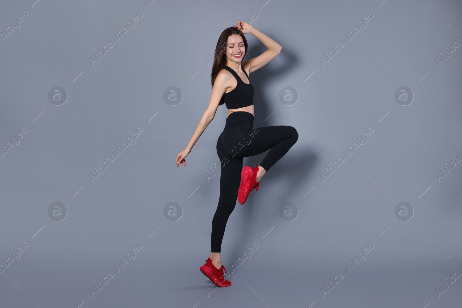 Photo of Beautiful woman in stylish sportswear on grey background