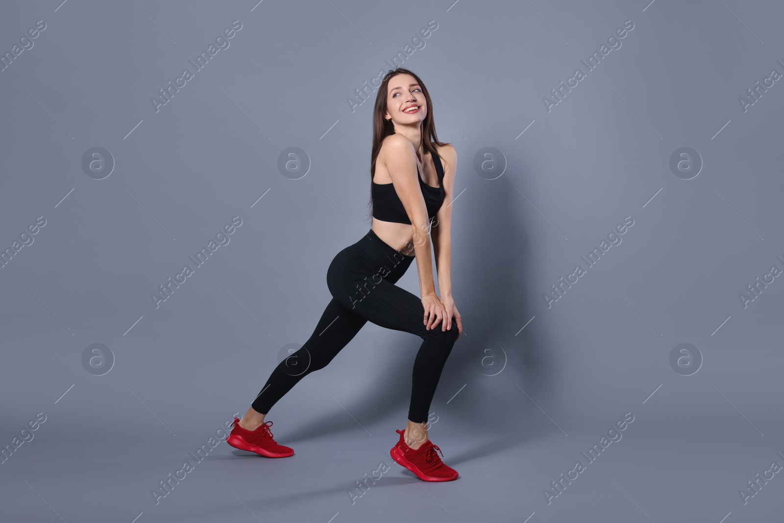 Photo of Beautiful woman in stylish sportswear on grey background