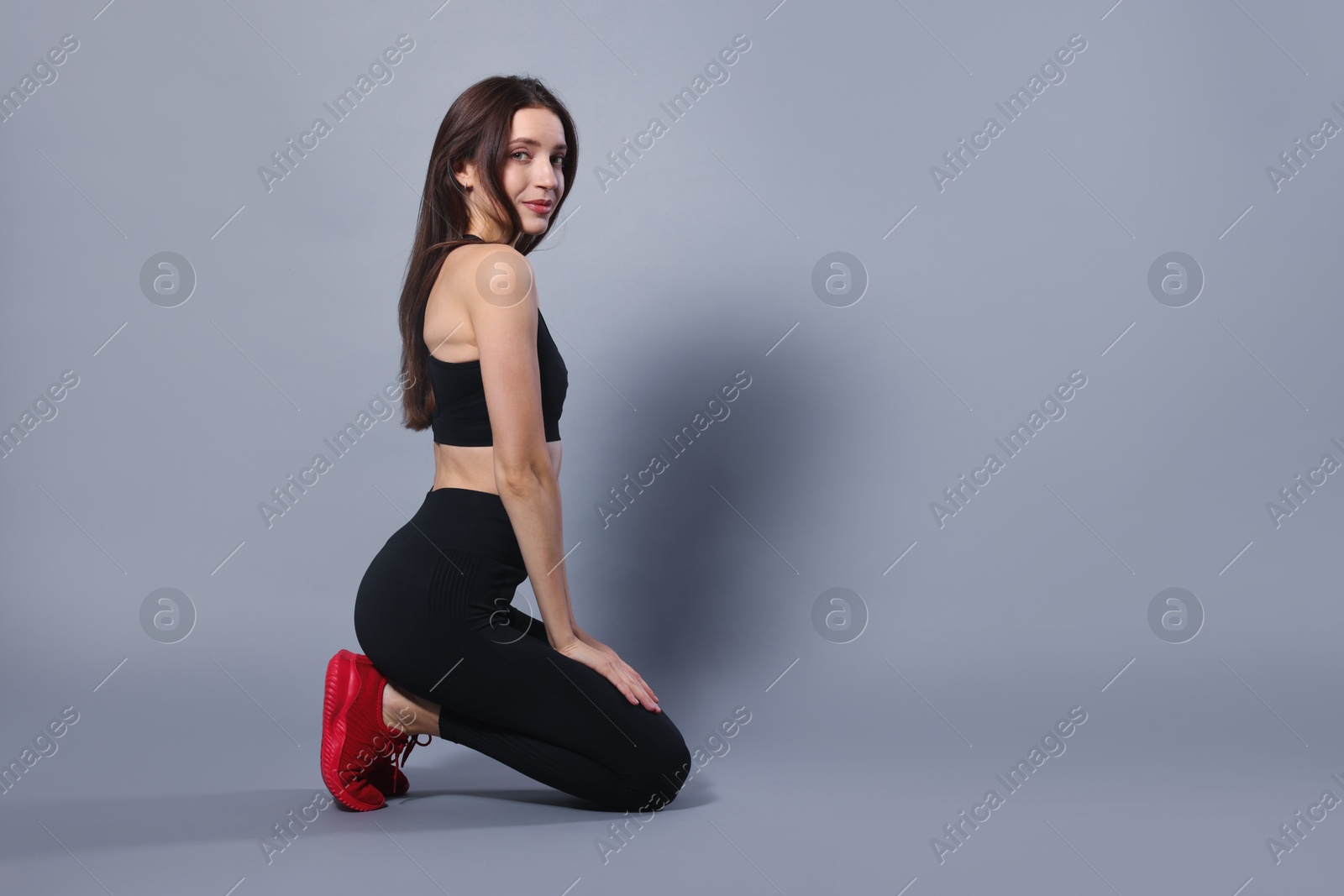 Photo of Beautiful woman in stylish sportswear on grey background. Space for text