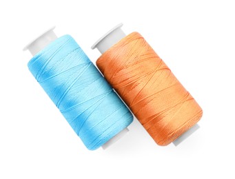 Photo of Spools of bright sewing threads isolated on white, top view