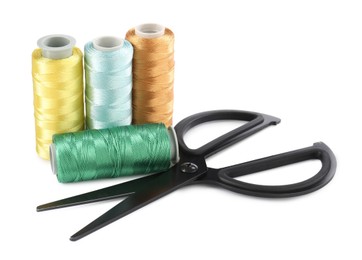 Photo of Spools of thread and scissors isolated on white. Sewing supplies