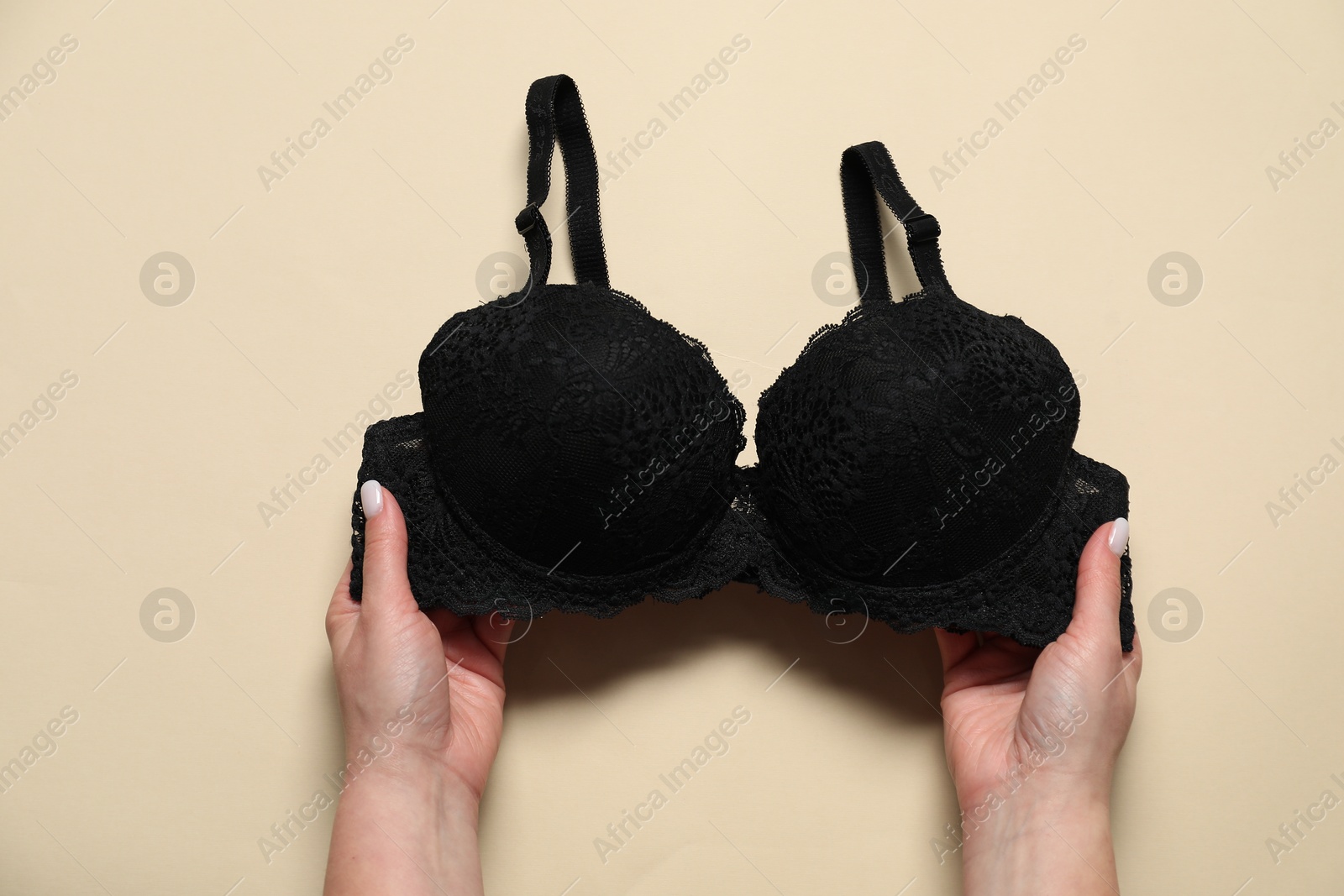 Photo of Woman with black bra on beige background, top view