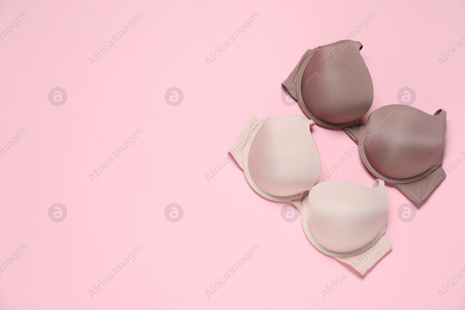 Photo of Beautiful bras on pale pink background, flat lay. Space for text