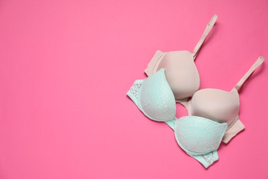 Photo of Beautiful bras on pink background, flat lay. Space for text