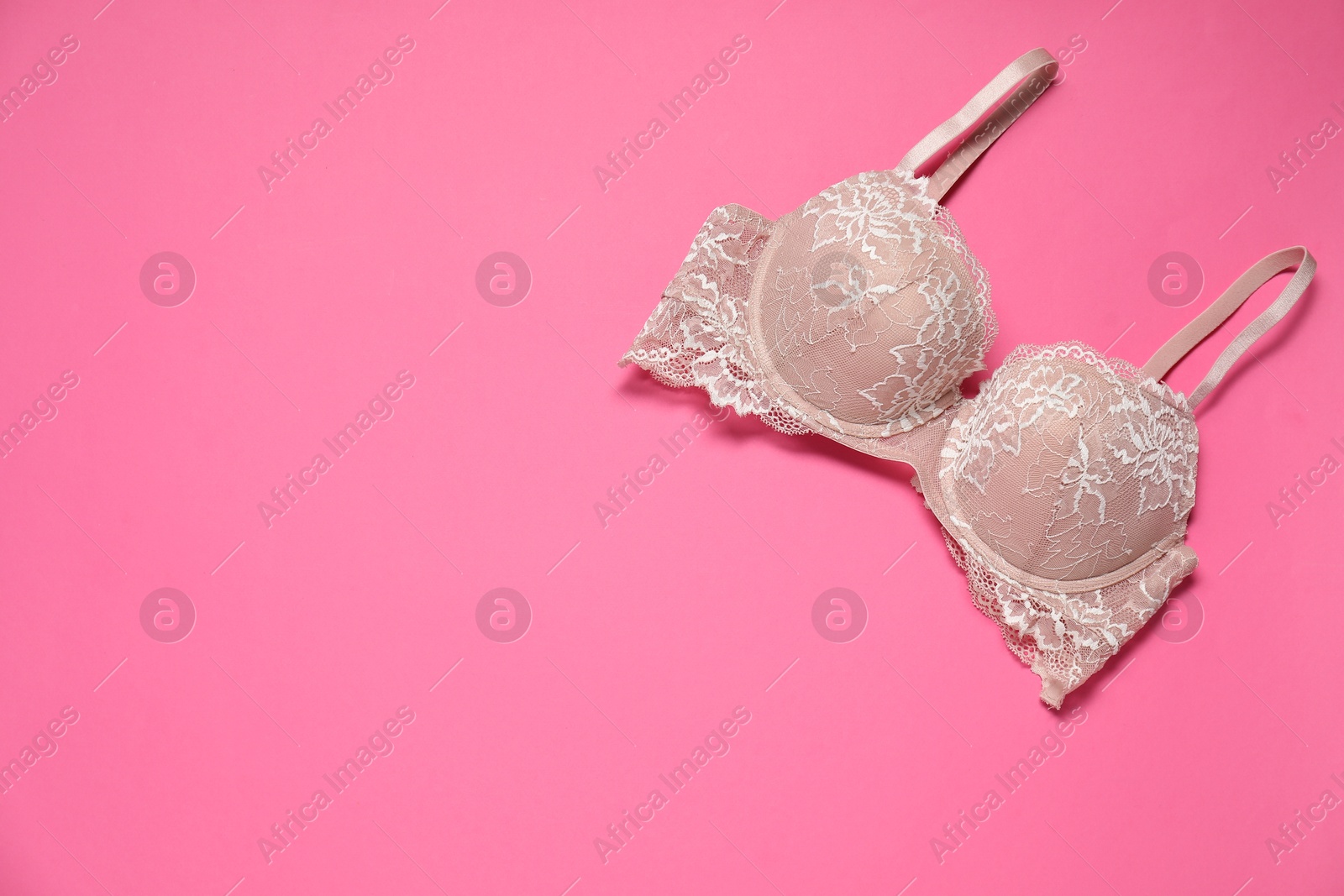 Photo of Beautiful lace bra on pink background, top view. Space for text