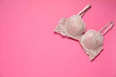 Photo of Beautiful lace bra on pink background, top view. Space for text