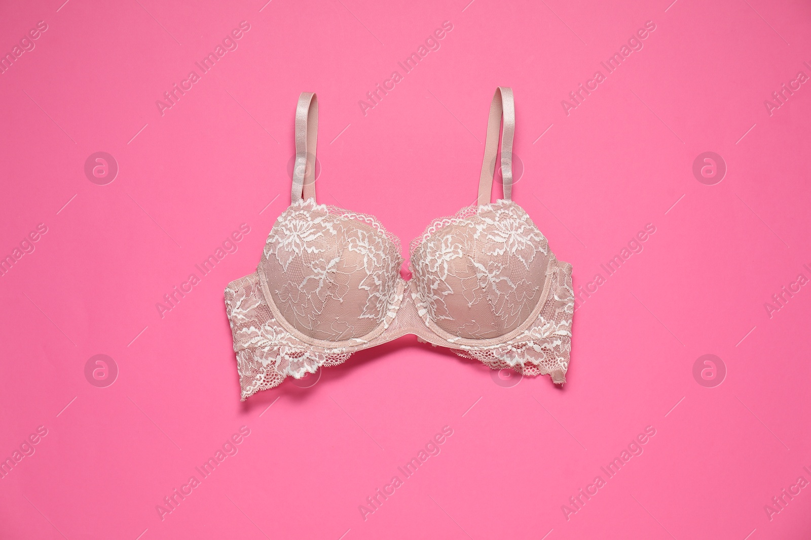 Photo of Beautiful lace bra on pink background, top view