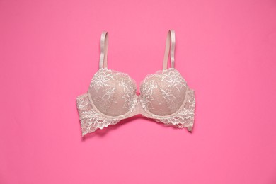 Photo of Beautiful lace bra on pink background, top view