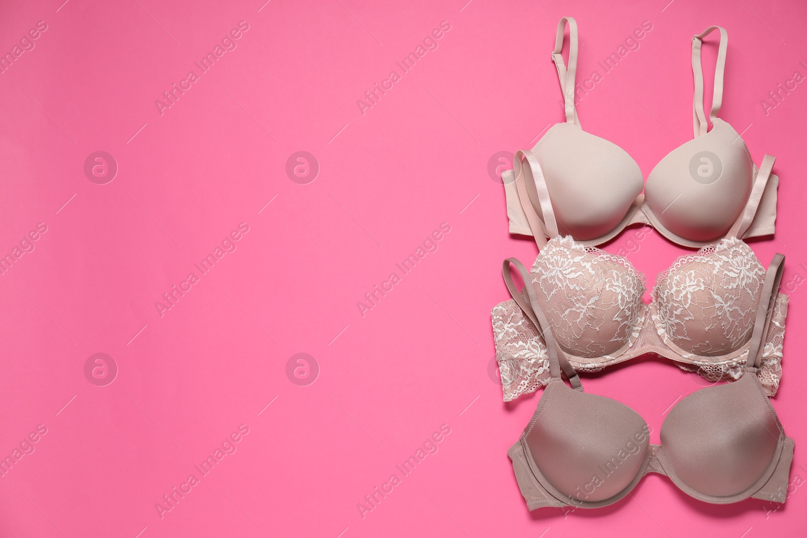 Photo of Beautiful bras on pink background, flat lay. Space for text