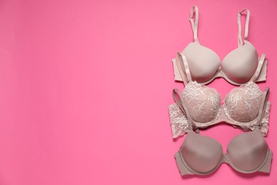 Photo of Beautiful bras on pink background, flat lay. Space for text