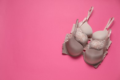 Photo of Beautiful bras on pink background, flat lay. Space for text