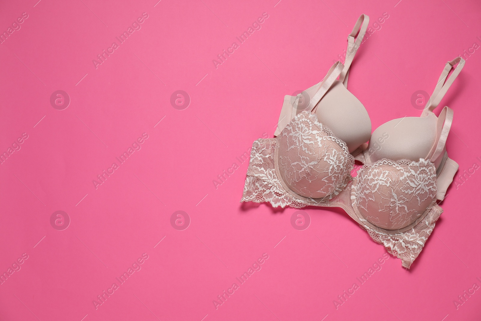 Photo of Beautiful bras on pink background, flat lay. Space for text