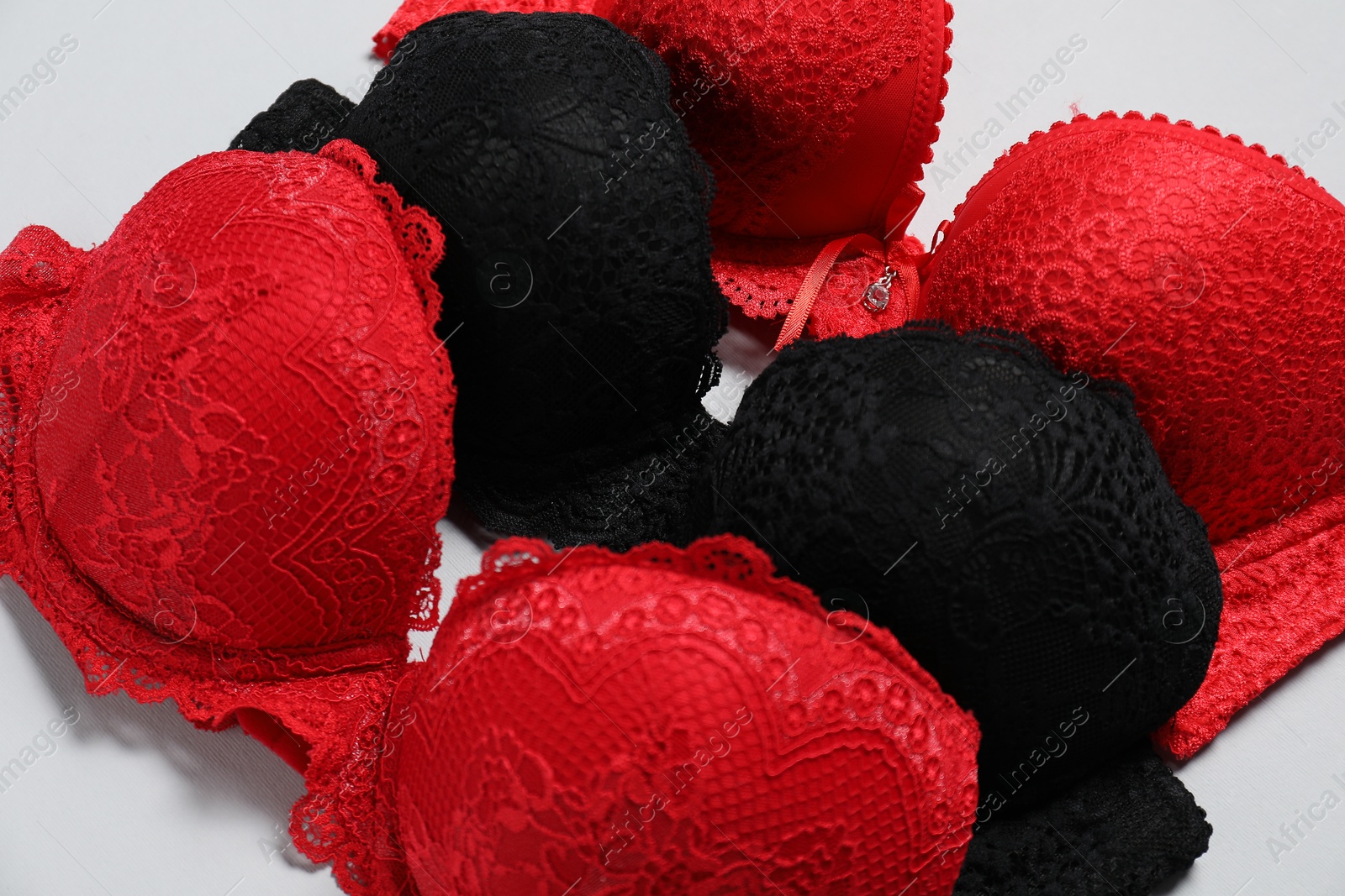 Photo of Beautiful lace bras on light background, closeup