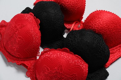 Photo of Beautiful lace bras on light background, closeup