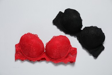 Photo of Beautiful lace bras on light background, flat lay