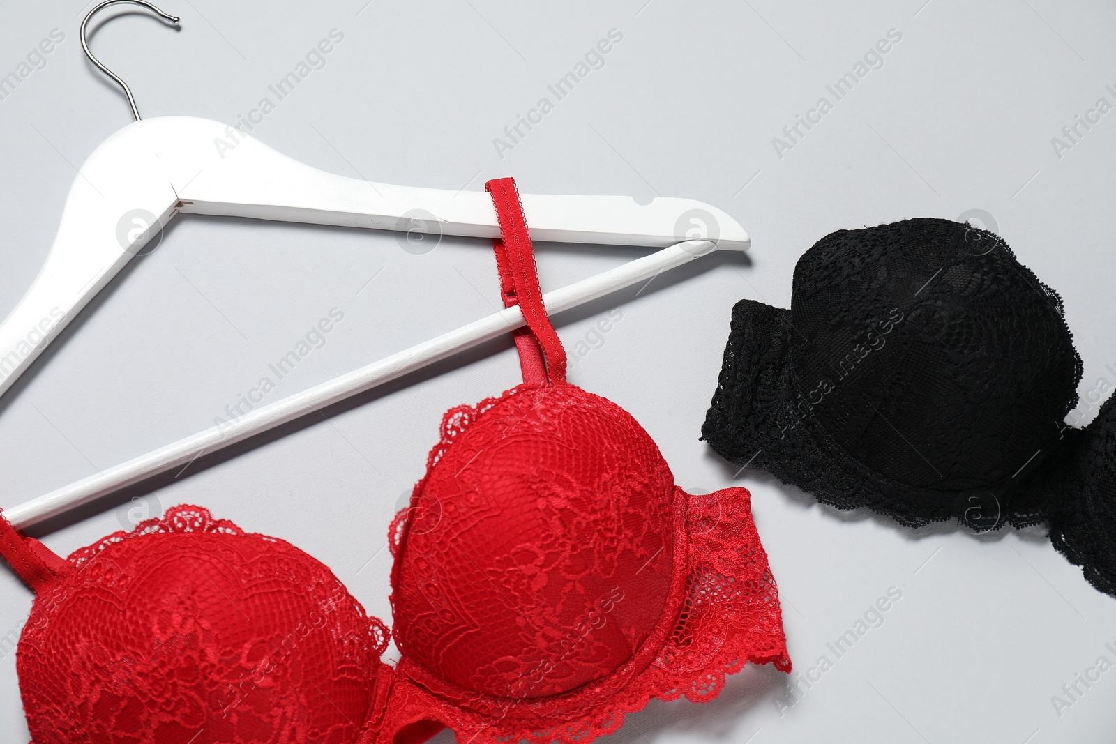 Photo of Beautiful lace bras on light background, above view