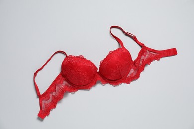 Photo of Beautiful red bra on light background, top view