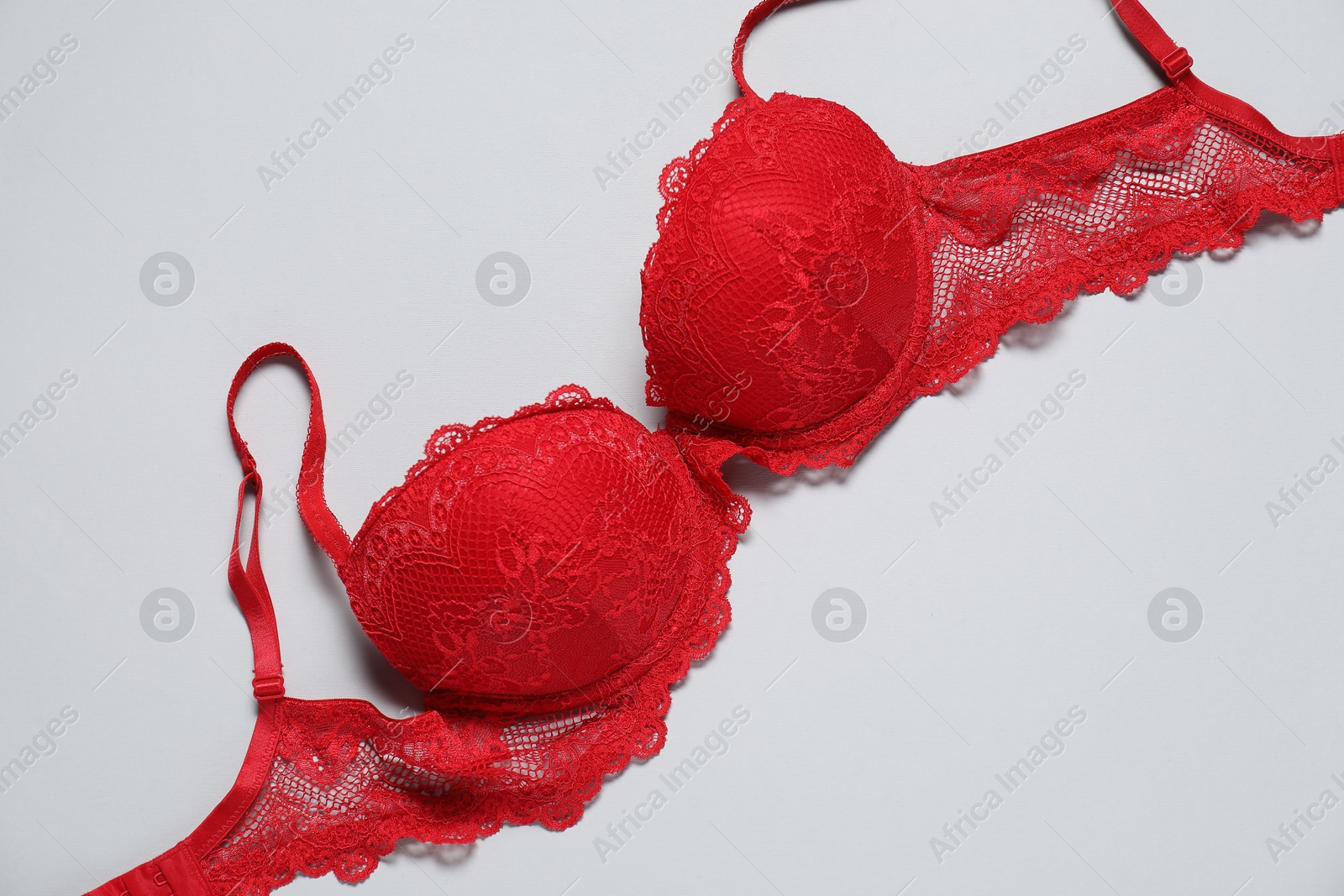 Photo of Beautiful red bra on light background, top view