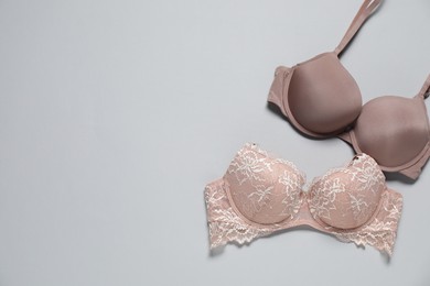 Photo of Beautiful bras on light background, flat lay. Space for text