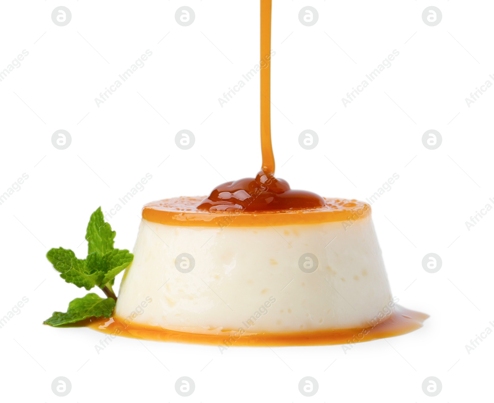 Photo of Pouring caramel sauce onto tasty pudding on white background