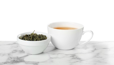 Refreshing green tea in cup and dry leaves on marble table against white background