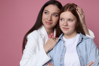 Photo of Family portrait of beautiful mother with teenage daughter on pink background