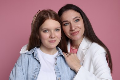 Photo of Family portrait of beautiful mother with teenage daughter on pink background