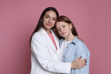 Photo of Family portrait of beautiful mother with teenage daughter on pink background