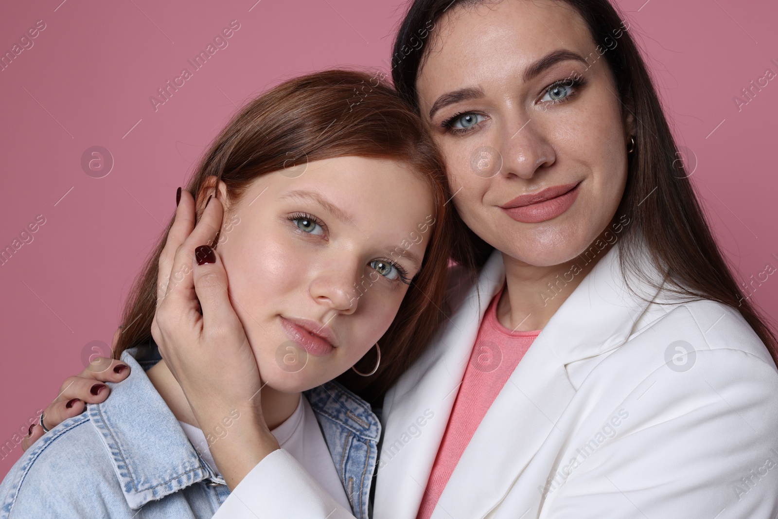 Photo of Family portrait of beautiful mother with teenage daughter on pink background