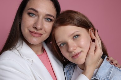 Photo of Family portrait of beautiful mother with teenage daughter on pink background