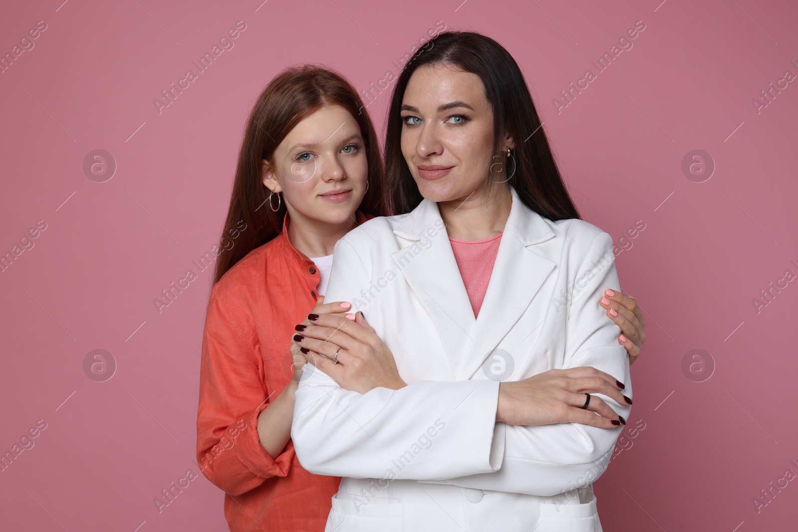 Photo of Family portrait of beautiful mother with teenage daughter on pink background