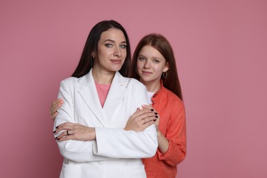 Photo of Family portrait of beautiful mother with teenage daughter on pink background