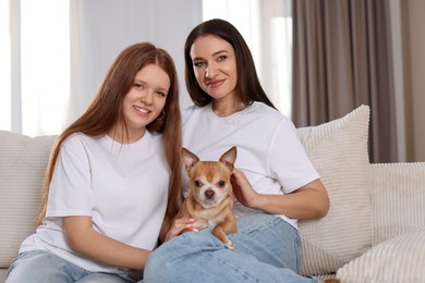 Photo of Portrait of beautiful mother with teenage daughter and cute Chihuahua dog on sofa at home