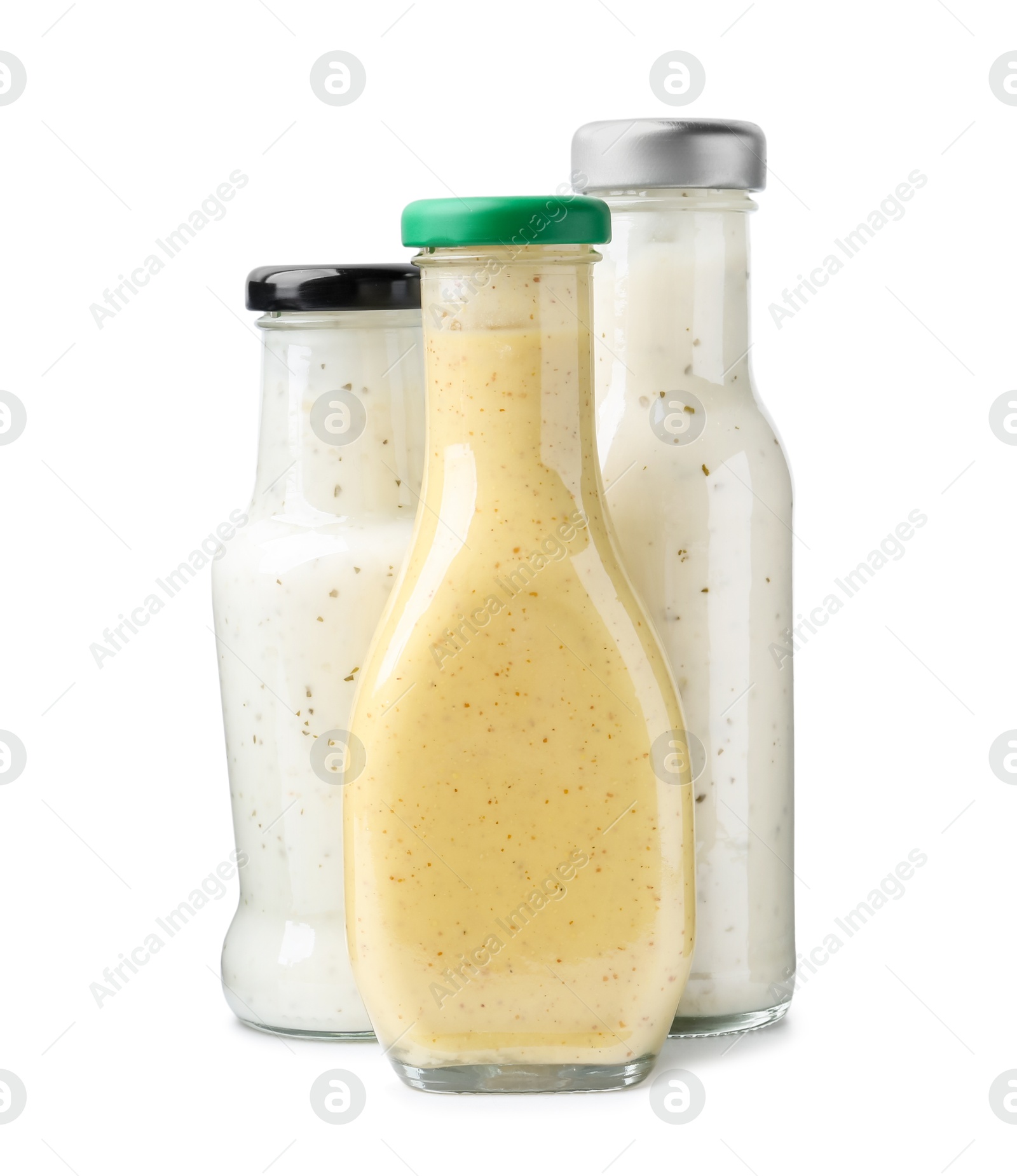 Photo of Different delicious sauces in glass bottles isolated on white