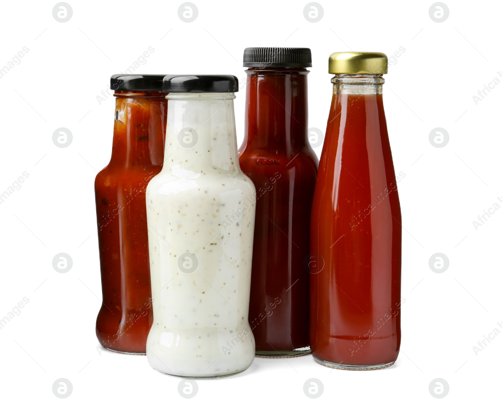 Photo of Different delicious sauces in glass bottles isolated on white