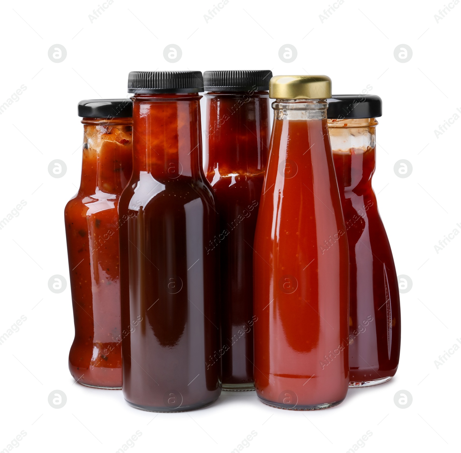 Photo of Different delicious sauces in glass bottles isolated on white