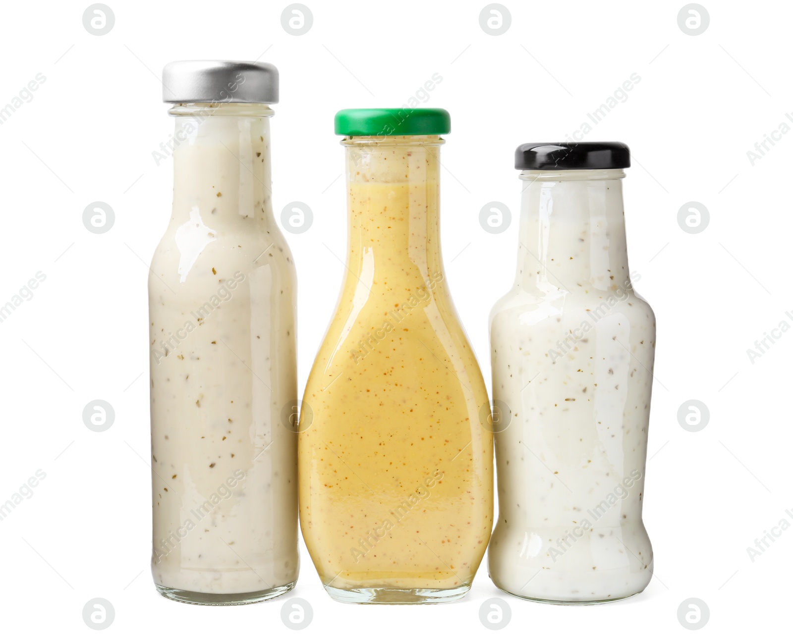 Photo of Different delicious sauces in glass bottles isolated on white