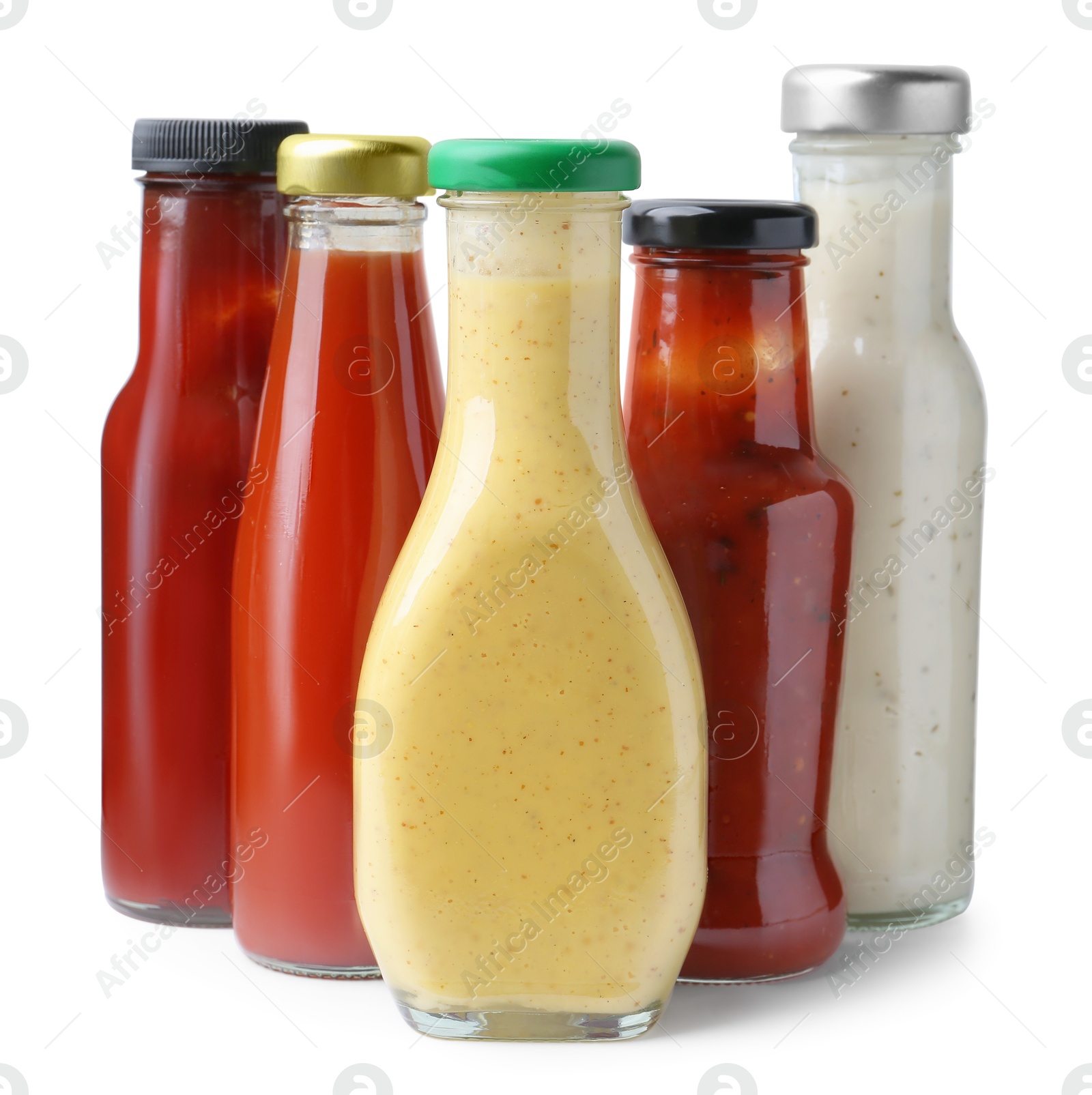 Photo of Different delicious sauces in glass bottles isolated on white