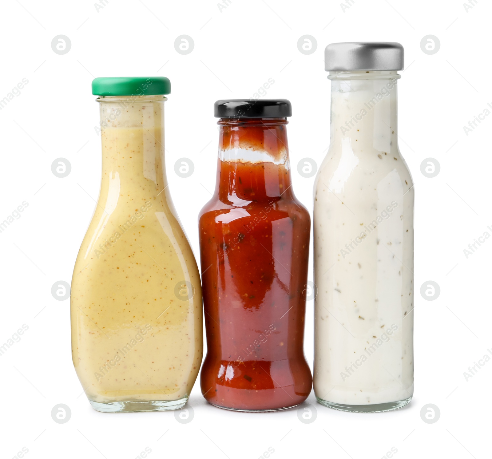 Photo of Different delicious sauces in glass bottles isolated on white